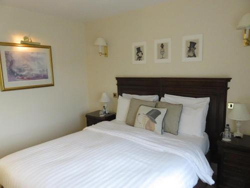 a bedroom with a large bed with white sheets and pillows at EBENEZER Cottage in Discovery Bay