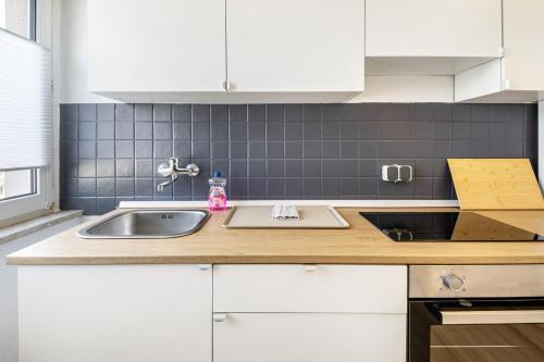 a kitchen with white cabinets and a sink at Ferienwohnung Mücheln in Mücheln
