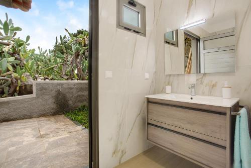 a bathroom with a sink and a mirror at Casa Do Vinho in Porto Santo