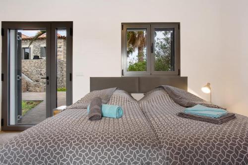a bedroom with a large bed with two windows at Casa Do Vinho in Porto Santo