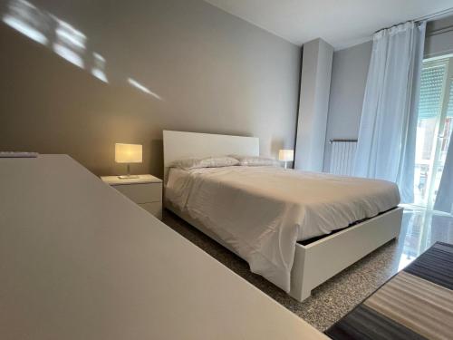a white bedroom with a bed and a window at Dimora Vibo Centro in Vibo Valentia