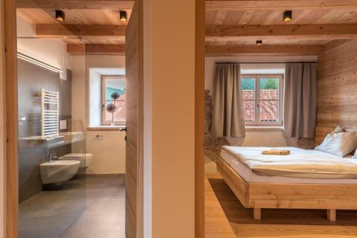 a bedroom with a bed and a bathroom at Egger an der Lahn - Apt Wald in San Genesio Atesino