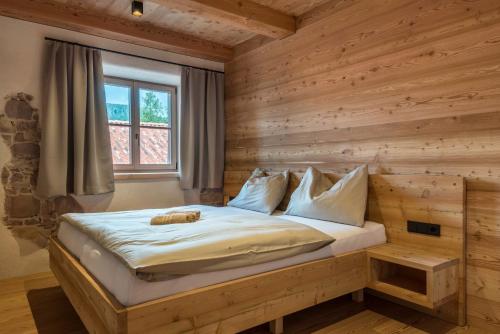 a bed in a room with a wooden wall at Egger an der Lahn - Apt Wald in San Genesio Atesino