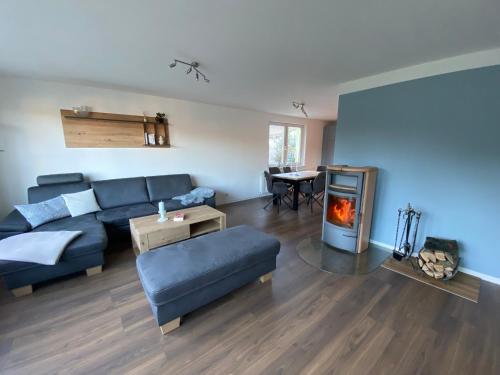 a living room with a blue couch and a fireplace at Ferienwohnung am Waldesrand in Heringsdorf