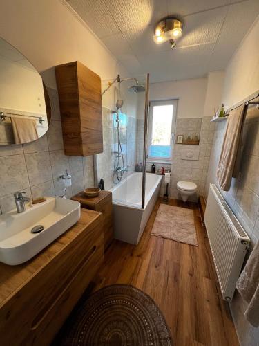 a bathroom with a sink and a tub and a toilet at Ferienwohnung am Waldesrand in Heringsdorf