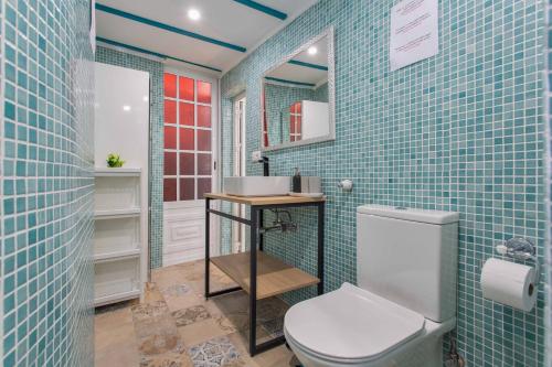 a bathroom with a toilet and blue tiled walls at Finca tropical Icod in Icod de los Vinos