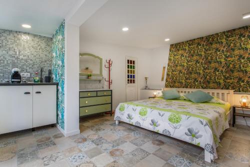 a bedroom with a large bed and a kitchen at Finca tropical Icod in Icod de los Vinos