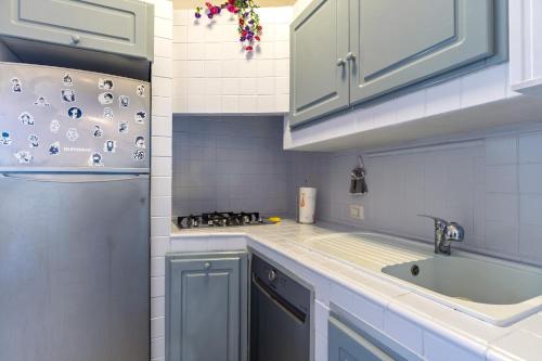 a kitchen with blue cabinets and a sink and a refrigerator at L'incanto in Palau