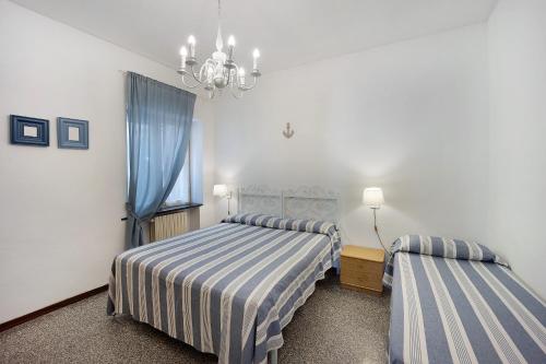 a bedroom with two beds and a chandelier at Appartamento Orizzonte 3 A in Diano Marina