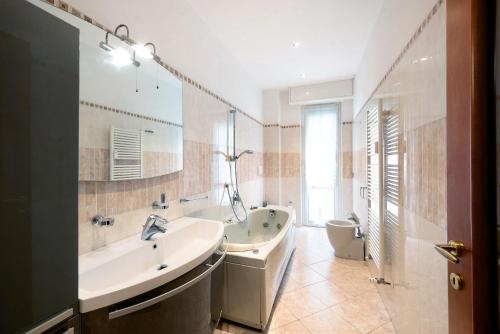 a bathroom with a tub and a sink and a toilet at Le Vele in Albissola Marina