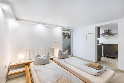 two beds in a room with a kitchen at Living the Green in Friedrichsdorf
