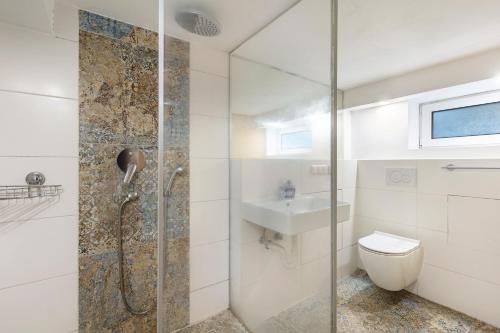 a bathroom with a shower and a toilet and a sink at Living the Green in Friedrichsdorf