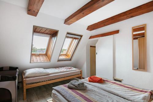 two beds in a room with two windows at Ferienhaus Engert mit Holzofensauna in Althüttendorf