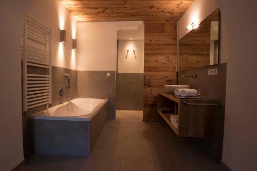 a bathroom with a tub and a sink at Greiterhof in Lana