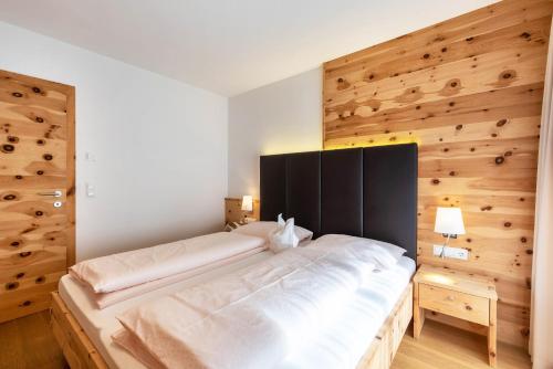 a bedroom with a large bed with a wooden wall at Apartments Marialisa Superior Orchi in Chiusa