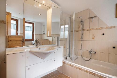 a bathroom with a sink and a shower and a tub at Ferienhaus Sundperle in Stralsund