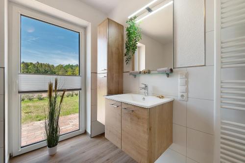 a bathroom with a sink and a large window at Gästehaus Anna in Suhle