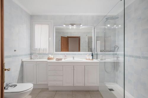 a white bathroom with a sink and a shower at Ca na Barons in Bunyola