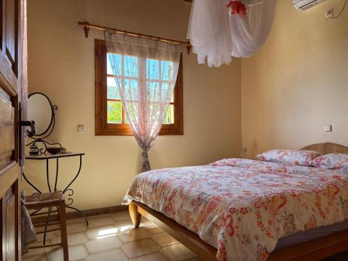 a bedroom with a bed and a window at Divas Gartenhaus in Vasilítsion