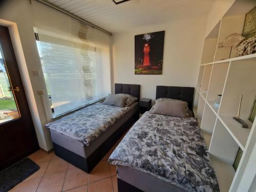 a bedroom with two beds and a window at Haus Meereswelle in Büsum