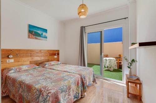 a bedroom with a bed and a large window at apto luminoso lagos del cotillo in La Oliva