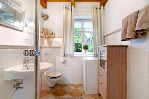 a bathroom with a sink toilet and a window at Green Oasis Ferienwohnung in Treia