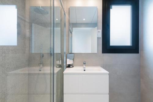 a bathroom with a sink and a glass shower at Ground floor 2bed Miradores del Sol in Estepona