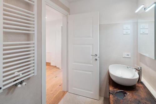 a bathroom with a white door and a sink at Casa Patty Moena in Moena