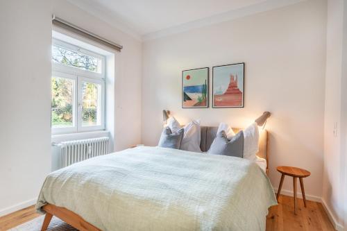 a white bedroom with a bed and two windows at Ferienwohnung Waldglück in Hinterzarten