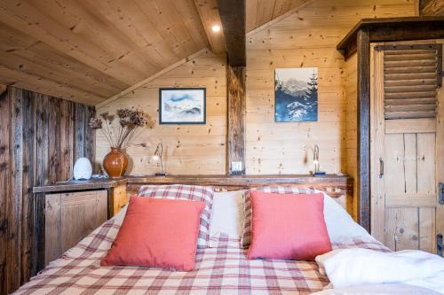 een slaapkamer met een bed met twee rode kussens bij Chalet Vardasse in Manigod
