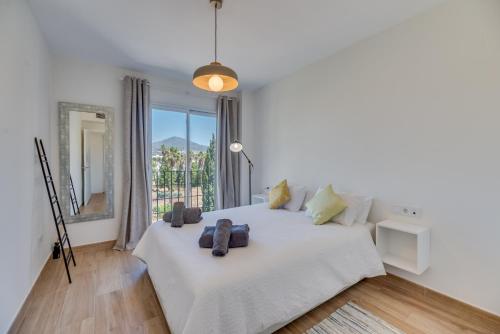a bedroom with a white bed with a large window at Marbella Beach San Pedro in Marbella