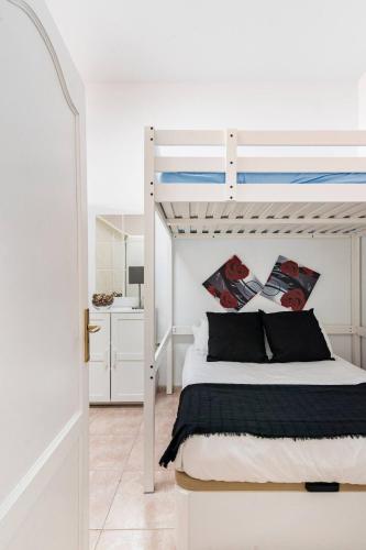 a bedroom with a white bunk bed and a kitchen at Apartamento La Listada Bajo in La Listada