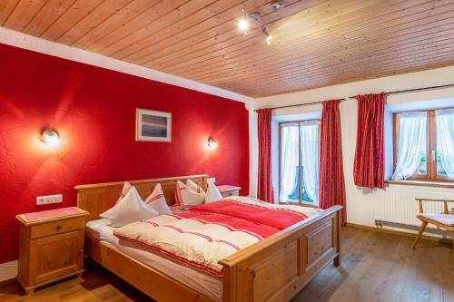 a bedroom with a red wall with a bed in it at Ferienwohnung Daniel in Grainau
