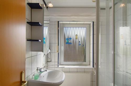 un bagno con lavandino, finestra e doccia di Ferienhaus Berdum a Wittmund