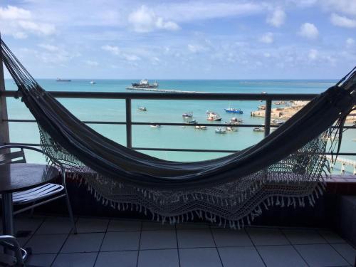 un'amaca sul balcone con vista sull'oceano di Yacht Cost Residence a Fortaleza