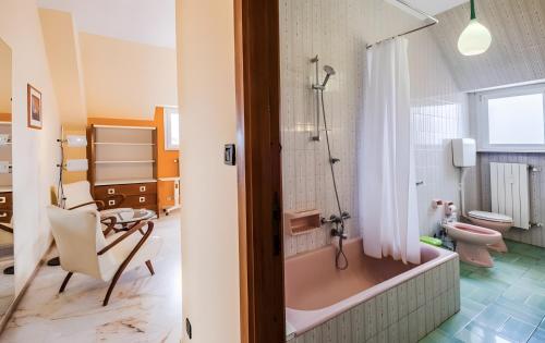 a bathroom with a pink tub and a toilet at La dimora di Alda in Lavagna