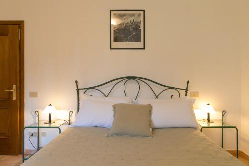 a bedroom with a bed with white pillows at Podere Nuti - 4 Lauro in Cecina