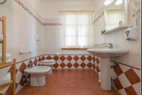 a bathroom with two toilets and a sink and a mirror at Podere Nuti - 4 Lauro in Cecina