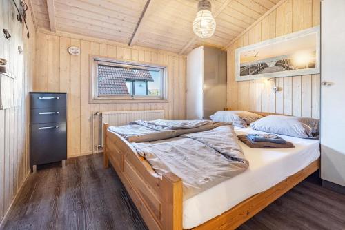 a bedroom with a bed in a room with wooden walls at Möwe in Twielenfleth
