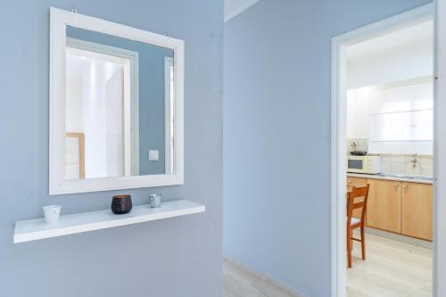 a bathroom with a mirror on a shelf and a kitchen at Eli Guesthouse in Kavos