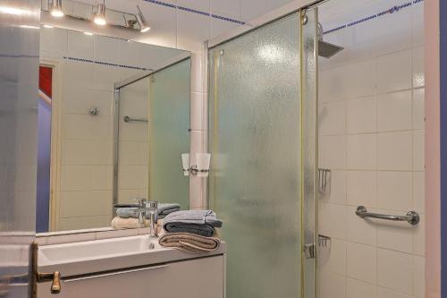 a bathroom with a shower and a sink and a mirror at Ti Bihan - Perros Guirec in Perros-Guirec