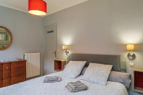 a bedroom with a bed with two pillows and a dresser at Ti Bihan - Perros Guirec in Perros-Guirec