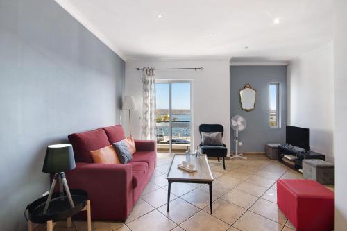a living room with a red couch and a tv at Duplex Apartamento Tartaruga in Santa Luzia