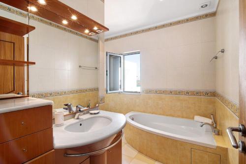 a bathroom with a tub and a sink at Duplex Apartamento Tartaruga in Santa Luzia