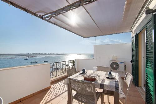 a balcony with a table and chairs and the ocean at Duplex Apartamento Tartaruga in Santa Luzia