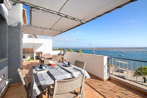 a balcony with a table and chairs and the ocean at Duplex Apartamento Tartaruga in Santa Luzia