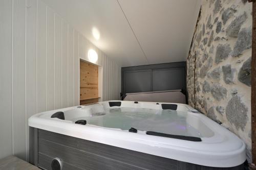 a large bath tub in a room with at Le Gite des 3000 avec Spa in Auzat
