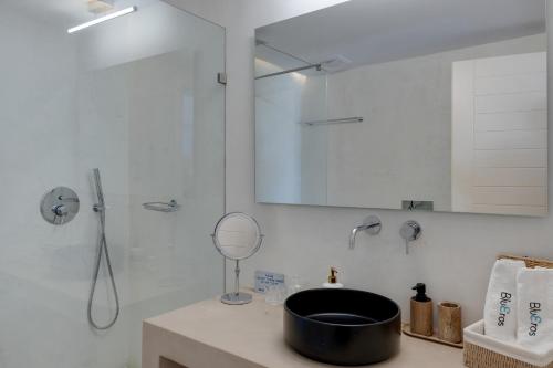 a bathroom with a sink and a shower with a mirror at Blueros - Main Villa in Megas Gialos - Nites