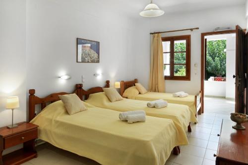a bedroom with three beds with yellow sheets at Studios Asterias 3 in Astypalaia
