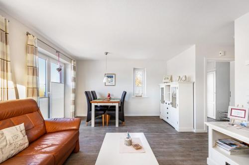 a living room with a couch and a table at Solarferienhaus Wolkenlos in Breklum